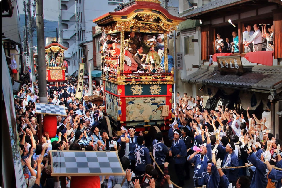 日本の伝統的な祭りで盛り上がる山車と人々。