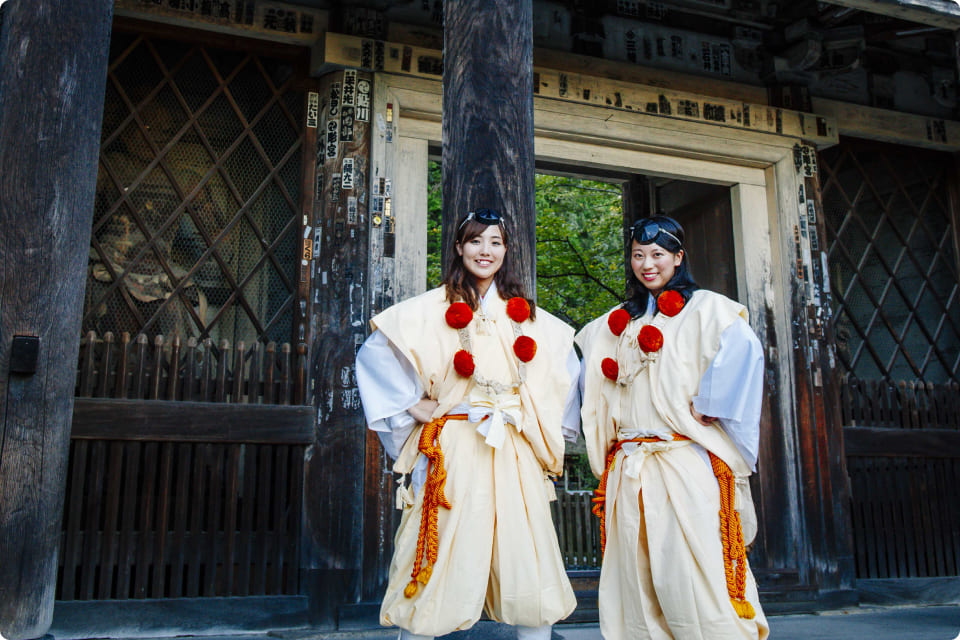 神社の境内で伝統的な神楽を奉納する巫女たち。